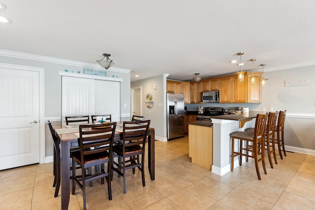 kitchen with a peninsula, a breakfast bar, appliances with stainless steel finishes, dark countertops, and crown molding