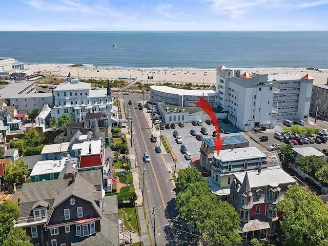 drone / aerial view featuring a water view and a beach view