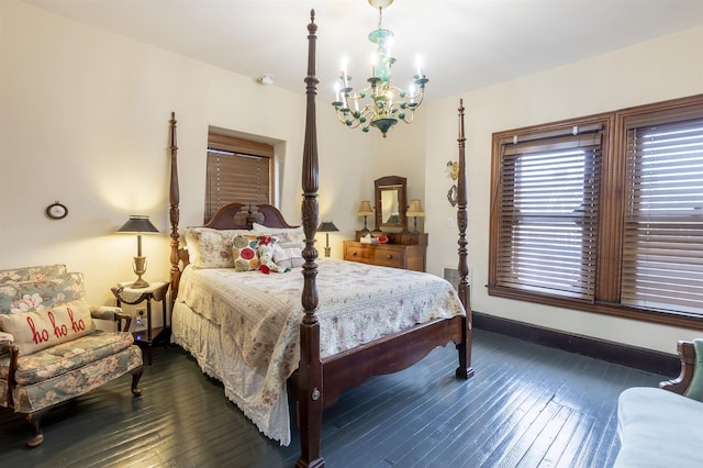bedroom with dark hardwood / wood-style floors and an inviting chandelier