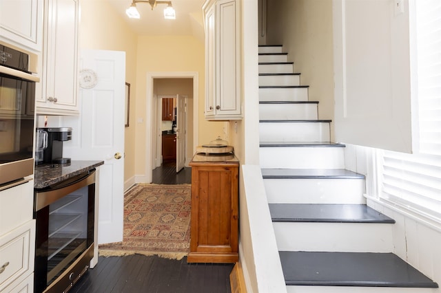 stairway with hardwood / wood-style flooring and beverage cooler