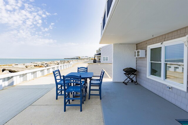 145 Seaview Ct Unit A7, North Wildwood, NJ 08260 - view of patio with view of water and beach, a wall mounted air conditioner, and outdoor dining space