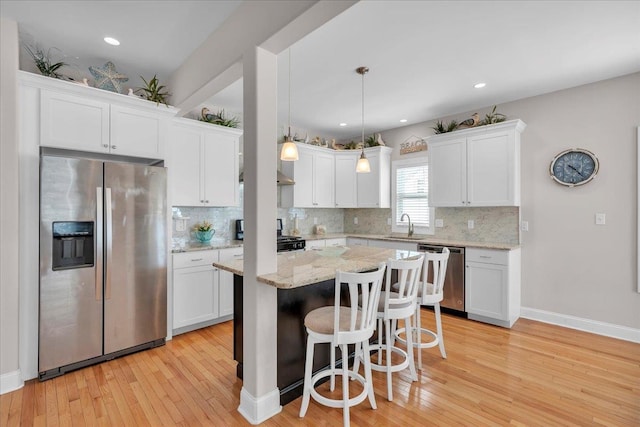 102 E 8 Th Ave, North Wildwood, NJ 08260 - kitchen featuring stainless steel appliances, a kitchen breakfast bar, white cabinets, light wood-type flooring, and recessed lighting