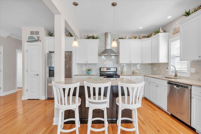 102 E 8 Th Ave, North Wildwood, NJ 08260 - kitchen featuring stainless steel appliances, wall chimney range hood, a kitchen island, a breakfast bar area, and recessed lighting