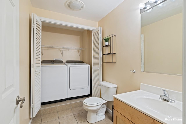 bathroom featuring vanity, washing machine and clothes dryer, tile patterned floors, and toilet