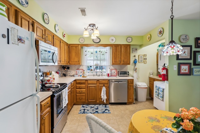2710 Bybrook Dr, Cape May Beach, NJ 08251 - kitchen featuring appliances with stainless steel finishes, light countertops, brown cabinets, and pendant lighting