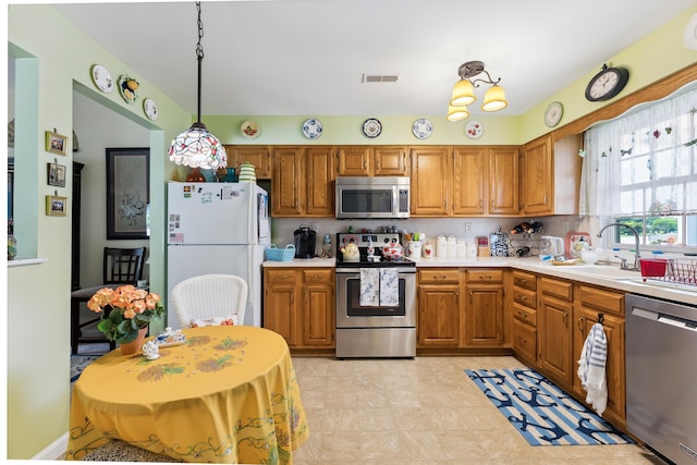 2710 Bybrook Dr, Cape May Beach, NJ 08251 - kitchen featuring stainless steel appliances, light countertops, brown cabinets, and decorative light fixtures