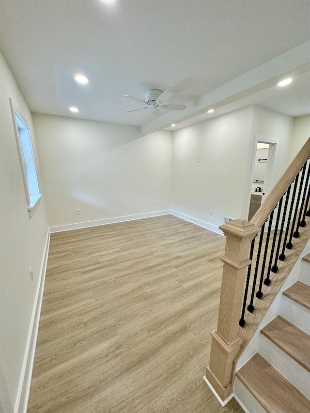 basement featuring ceiling fan and light wood-type flooring