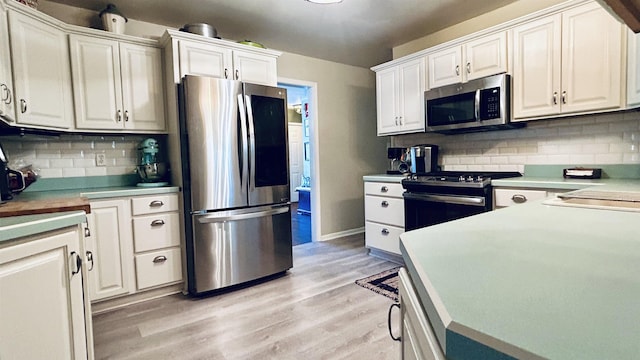 kitchen featuring backsplash, stainless steel appliances, white cabinetry, and light hardwood / wood-style floors