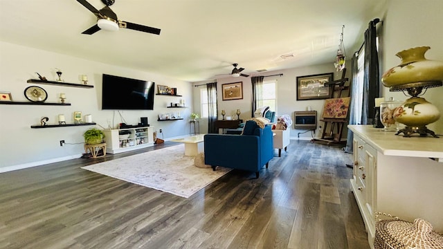 living room with dark hardwood / wood-style floors, ceiling fan, and heating unit