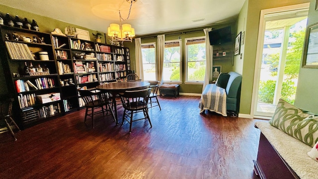 dining room featuring dark hardwood / wood-style floors and an inviting chandelier