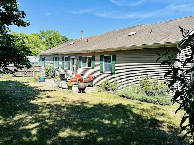 rear view of house featuring a lawn and a patio