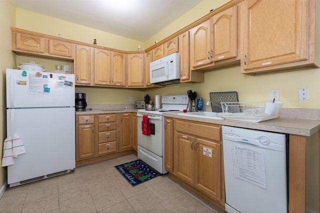 kitchen featuring light tile patterned flooring, light brown cabinets, and white appliances