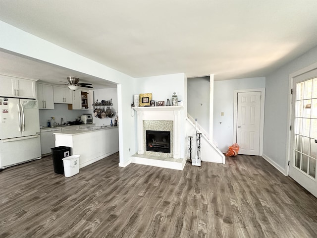 110 S 9th St, Del Haven, NJ 08251 - living area with dark wood-style floors, a ceiling fan, a fireplace with raised hearth, and baseboards