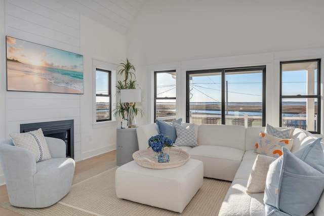 615 W Spruce Ave, North Wildwood, NJ 08260 - living area with baseboards, a water view, wood finished floors, a large fireplace, and high vaulted ceiling