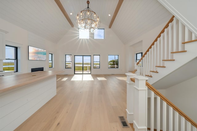 615 W Spruce Ave, North Wildwood, NJ 08260 - entrance foyer with a notable chandelier, light wood-type flooring, a fireplace, visible vents, and high vaulted ceiling