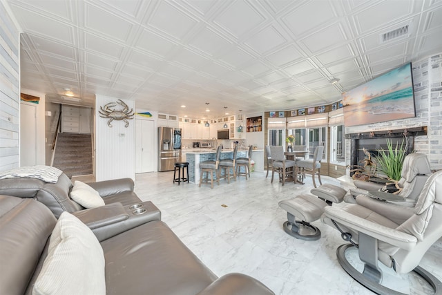 902 Ocean Dr Unit 302, Lower Township, NJ 08204 - living area featuring stairs, an ornate ceiling, a fireplace, and light marble finish floors