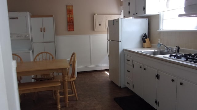 309 E Topeka Ave, Wildwood Crest, NJ 08260 - kitchen featuring sink, range hood, stacked washer and dryer, white appliances, and white cabinets