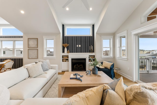 living room with light hardwood / wood-style floors, vaulted ceiling, and plenty of natural light