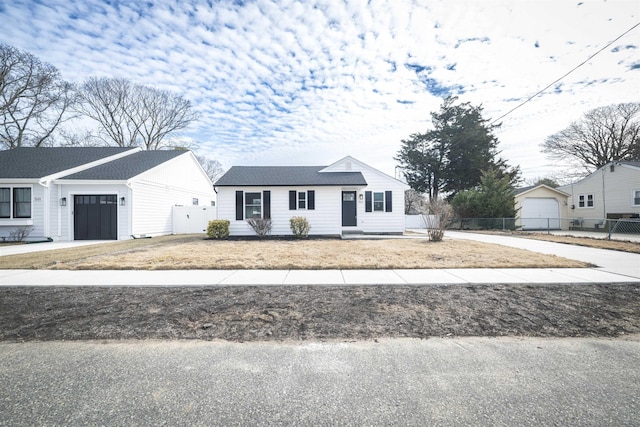 view of front facade with an attached garage, fence, and concrete driveway