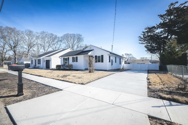 view of front of property featuring driveway and fence