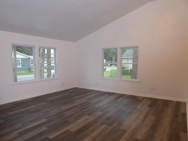 spare room with lofted ceiling, dark wood-style flooring, and baseboards