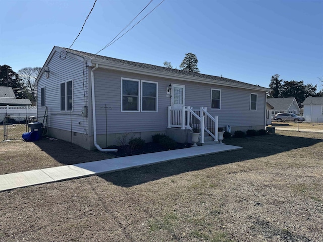 view of front facade with crawl space, fence, and a front yard