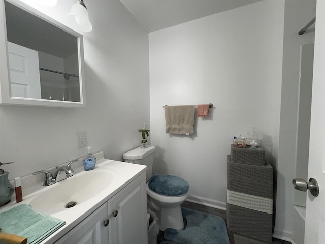 bathroom with toilet, a shower, and vanity