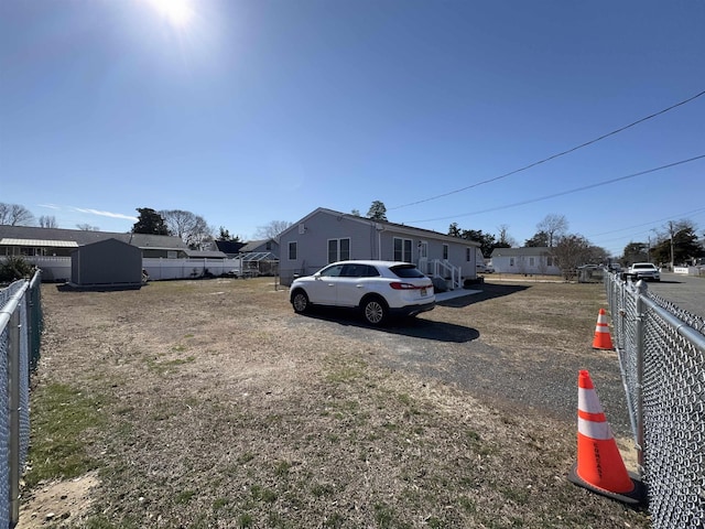 view of yard featuring a storage unit, fence, and an outbuilding