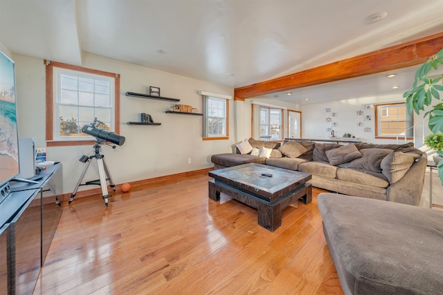 living room featuring beam ceiling and light hardwood / wood-style flooring