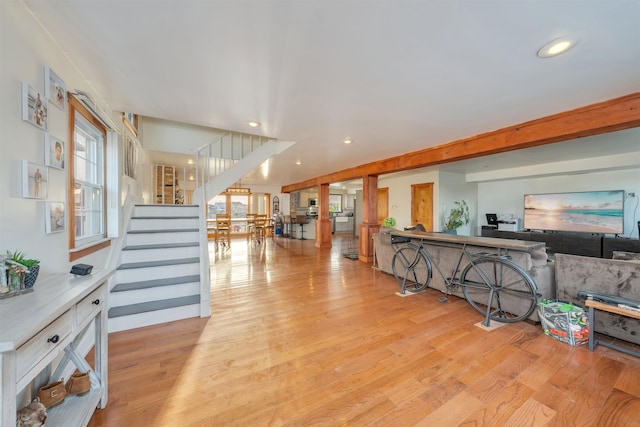 interior space featuring beam ceiling and light wood-type flooring