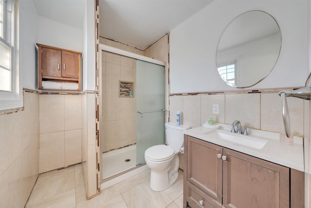 bathroom with tile walls, tile patterned flooring, vanity, toilet, and a shower with door