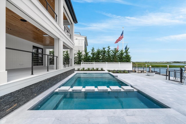 view of swimming pool featuring a patio area, a water view, and an in ground hot tub