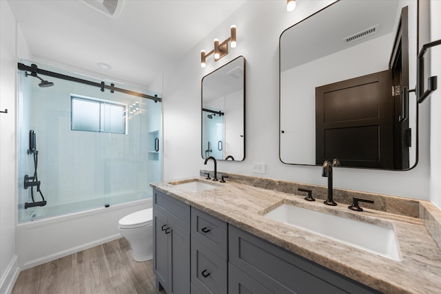 full bathroom featuring toilet, vanity, bath / shower combo with glass door, and wood-type flooring