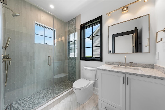 bathroom with tile patterned floors, vanity, toilet, and a shower with door