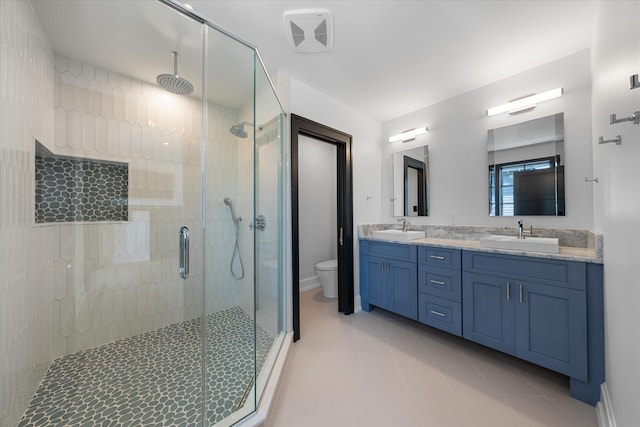 bathroom with tile patterned floors, vanity, toilet, and an enclosed shower