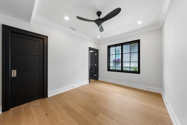 spare room with ceiling fan, ornamental molding, and light wood-type flooring