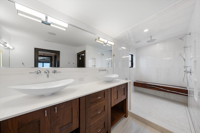 bathroom featuring vanity, tile walls, and tiled shower