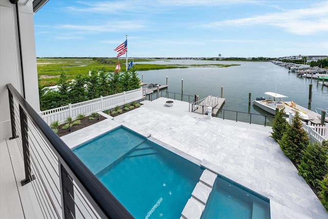 view of pool with a patio area, a water view, and a dock