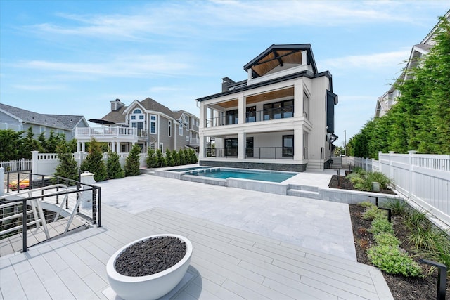 back of house featuring a patio area, a balcony, and a fenced in pool