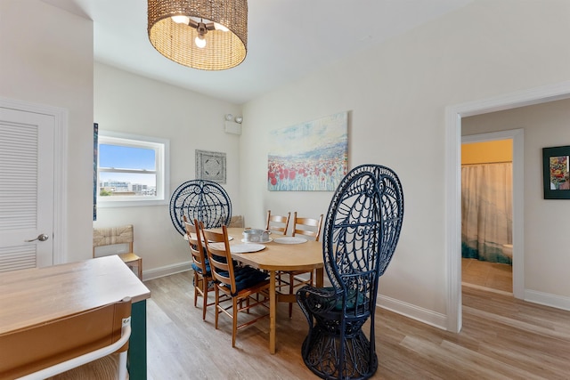 dining area with baseboards and wood finished floors