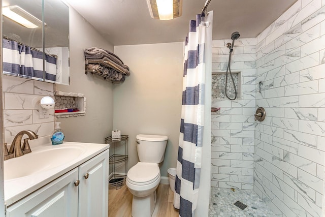 bathroom with hardwood / wood-style flooring, toilet, vanity, and walk in shower