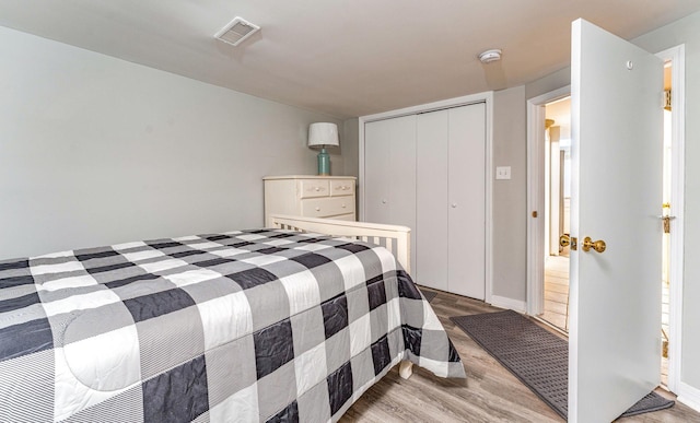 bedroom with light hardwood / wood-style flooring and a closet