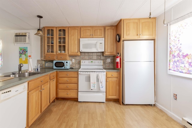 kitchen featuring pendant lighting, sink, white appliances, baseboard heating, and a wall unit AC