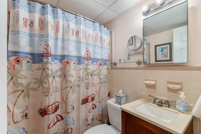 1800 Atlantic Ave Unit 103, North Wildwood, NJ 08260 - bathroom featuring a drop ceiling, vanity, tile walls, a shower with curtain, and a wainscoted wall