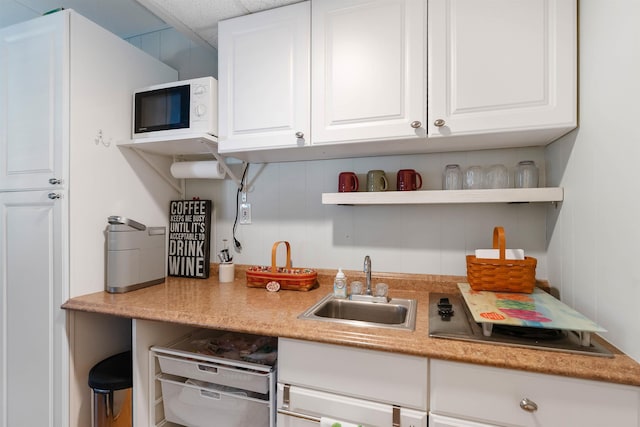 1800 Atlantic Ave Unit 103, North Wildwood, NJ 08260 - kitchen featuring white microwave, white cabinetry, open shelves, light countertops, and a drop ceiling
