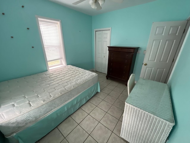 bedroom featuring light tile patterned floors, a closet, and ceiling fan