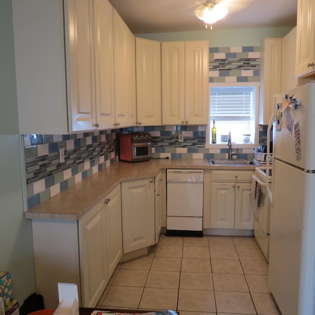 kitchen with decorative backsplash, white appliances, sink, white cabinets, and light tile patterned flooring