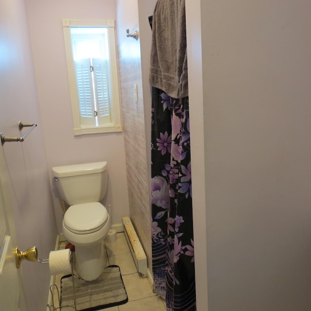 bathroom with tile patterned flooring, toilet, and curtained shower