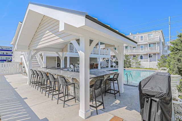 view of pool with a fenced in pool, area for grilling, a gazebo, fence, and a bar