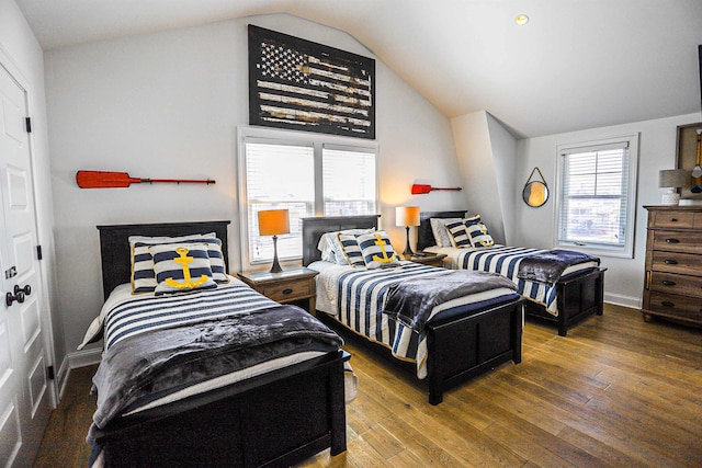 bedroom with dark wood-style floors, lofted ceiling, and baseboards